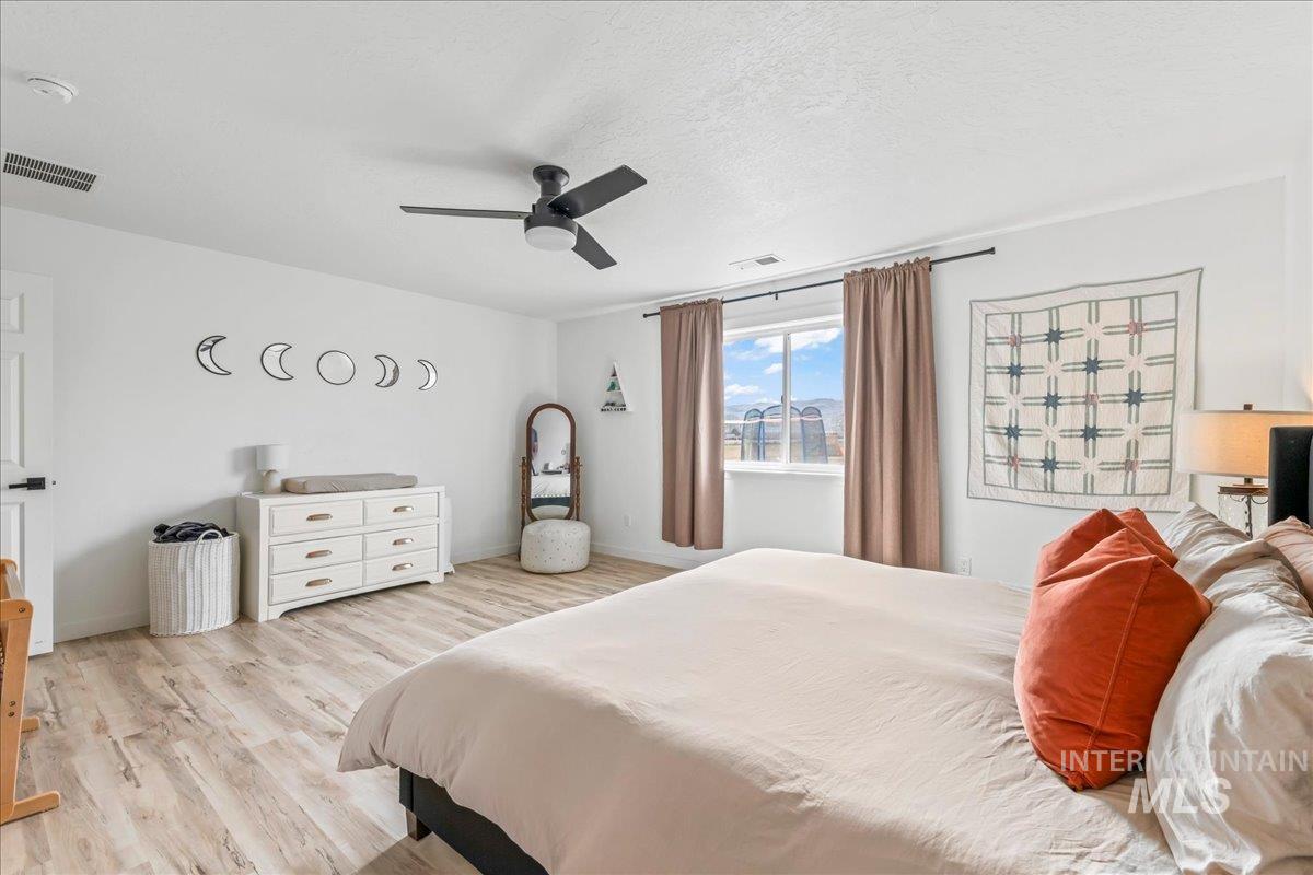 8843 Highway 78 Marsing, ID 83639 - Photo 25 of 48 Bedroom featuring light wood-style floors, a ceiling fan, and a textured ceiling