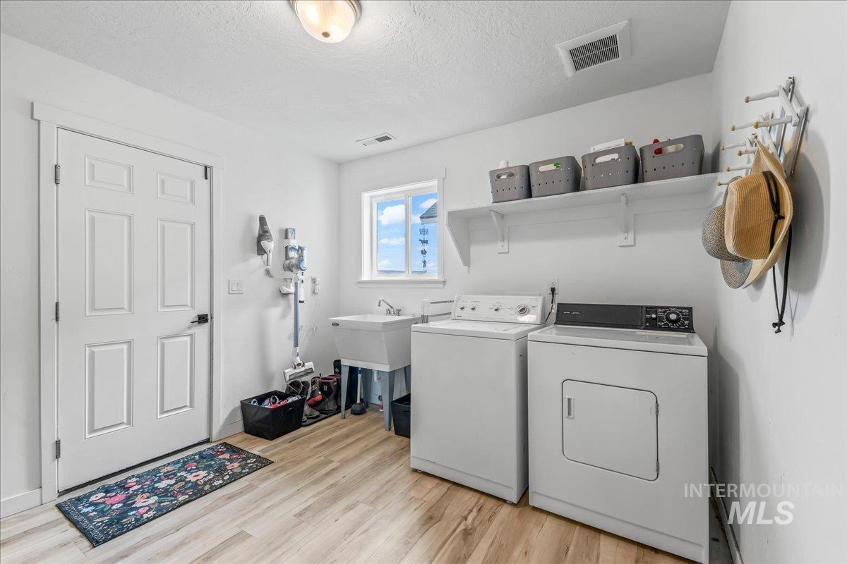8843 Highway 78 Marsing, ID 83639 - Photo 28 of 48 Laundry area featuring a textured ceiling, light wood finished floors, and washer and dryer