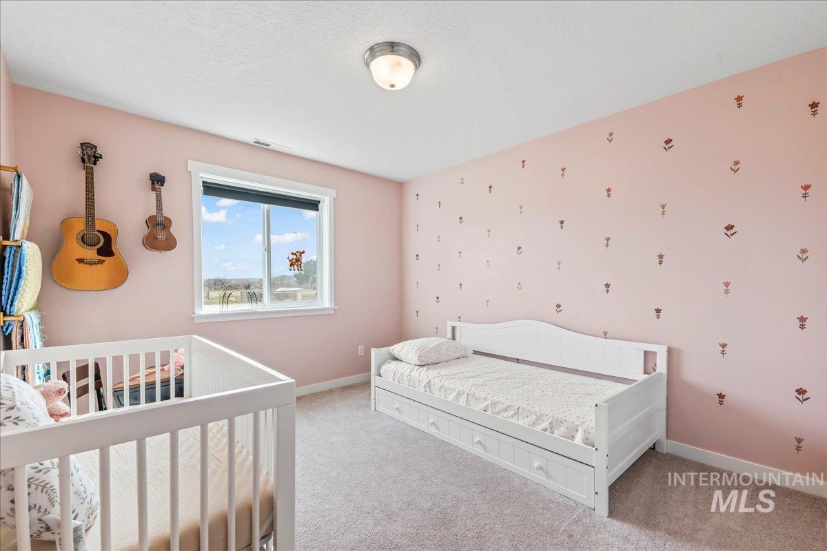 8843 Highway 78 Marsing, ID 83639 - Photo 31 of 48 Carpeted bedroom featuring wallpapered walls and a nursery area