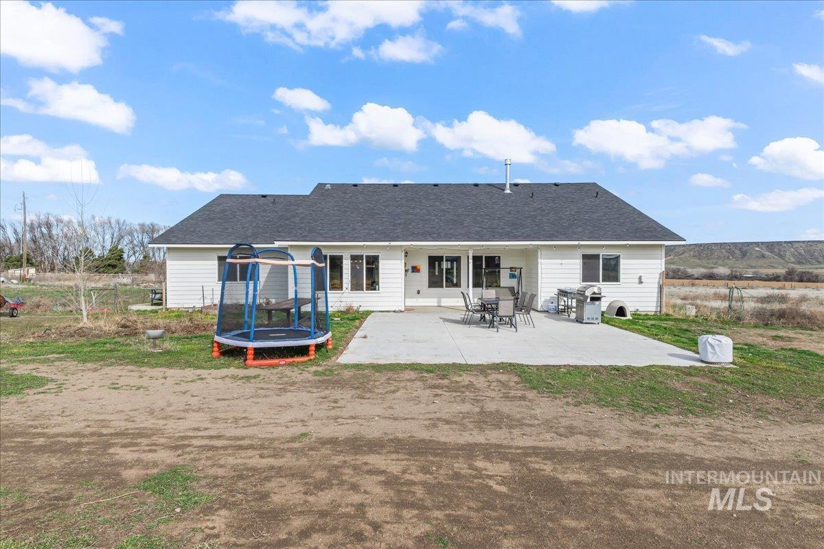 8843 Highway 78 Marsing, ID 83639 - Photo 37 of 48 Rear view of property with a trampoline, a patio area, and roof with shingles