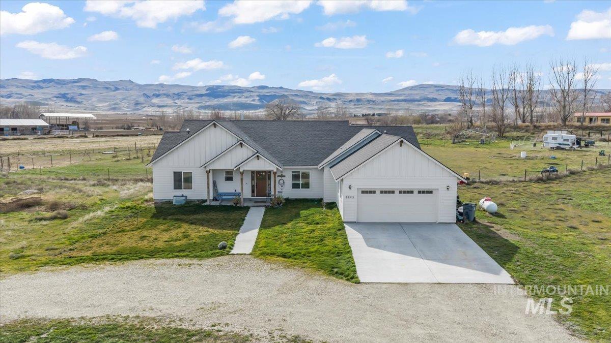 8843 Highway 78 Marsing, ID 83639 - Photo 40 of 48 View of front facade with driveway, a porch, board and batten siding, roof with shingles, and a front lawn
