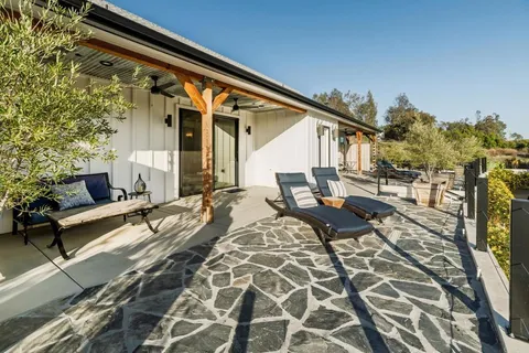 a kitchen with stainless steel appliances granite countertop table chairs sink and cabinets