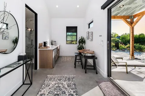 a kitchen with a stove a sink a counter top space and living room view