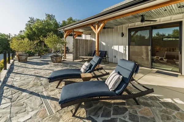 a view of a patio with table and chairs with wooden floor and fence