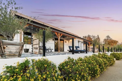 a view of a patio with table and chairs with wooden floor and fence