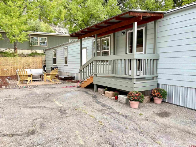 a backyard of a house with barbeque oven table and chairs