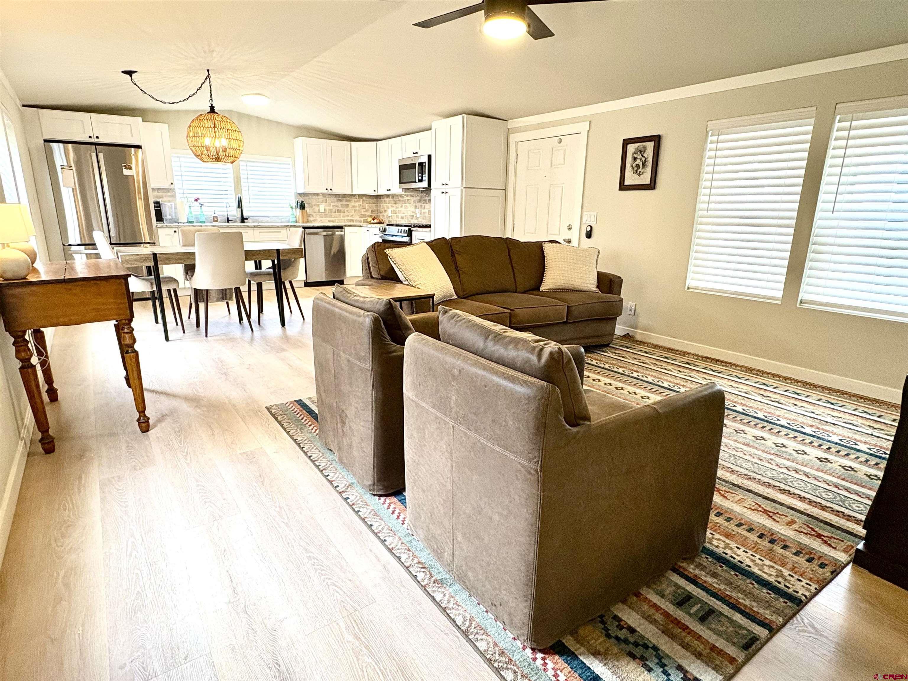 288 Animas View Drive, Unit 11 Durango, CO 81301 - Photo 16 of 23 a living room with couches and kitchen view with wooden floor