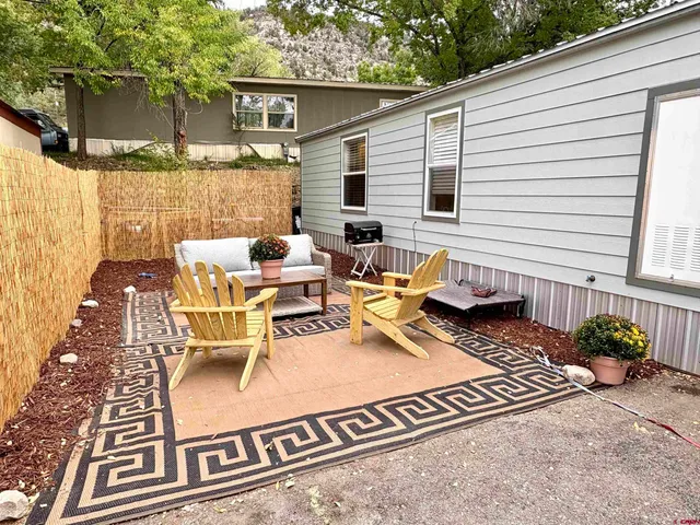 a view of a patio with couple of chairs and a table
