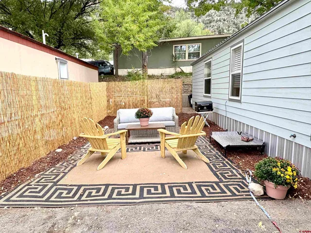 a view of a patio with couches table and chairs and potted plants