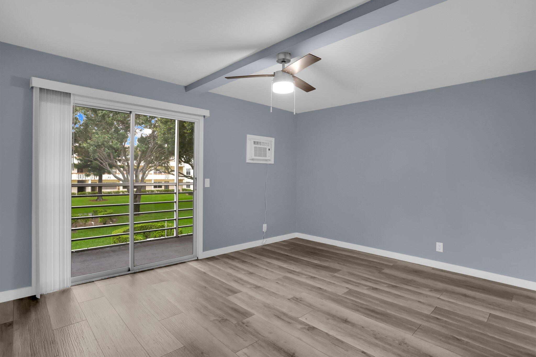 104 Mansfield C, Unit C Boca Raton, FL 33434 - Photo 11 of 40 a view of a room with wooden floor and windows