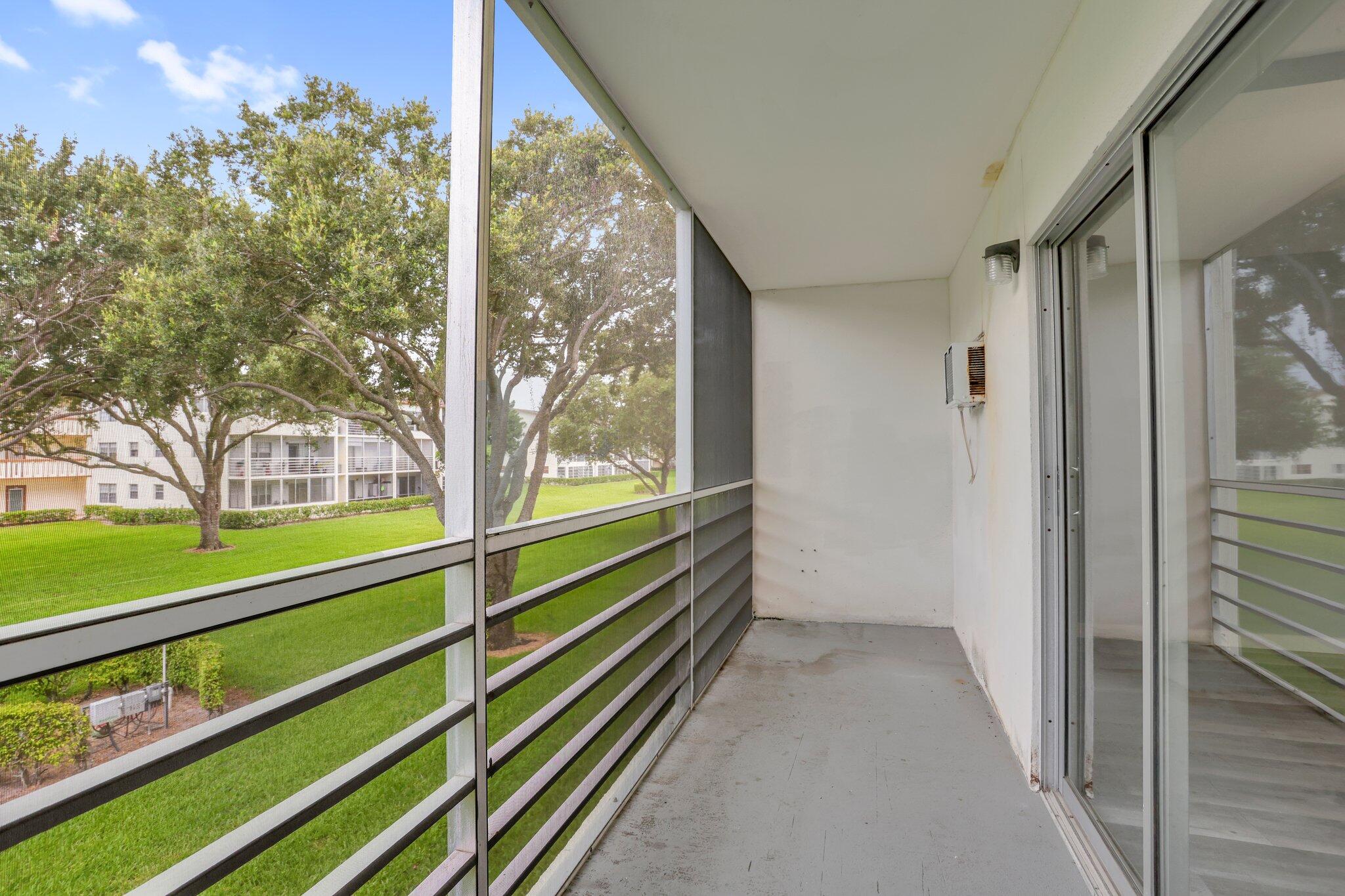 104 Mansfield C, Unit C Boca Raton, FL 33434 - Photo 16 of 40 a view of balcony with floor to ceiling windows and wooden floor