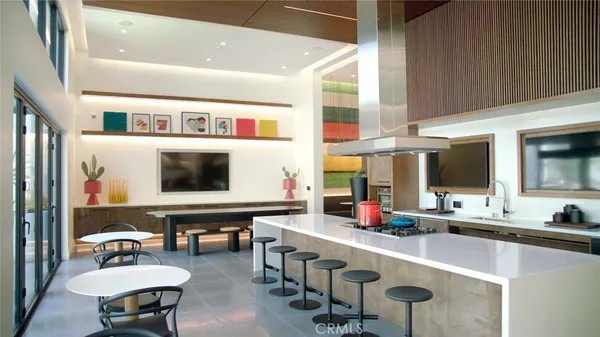 a kitchen with stainless steel appliances kitchen island granite countertop a table and chairs in it