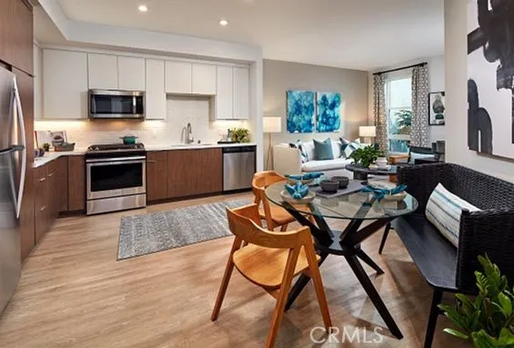a kitchen with a dining table chairs and refrigerator