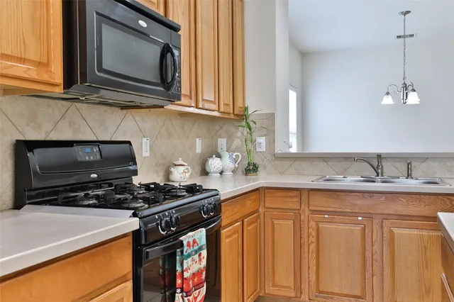 a kitchen with granite countertop a sink stove and microwave
