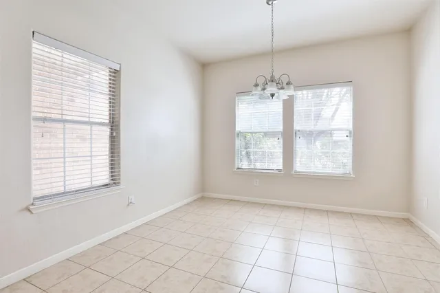 an empty room with windows and chandelier