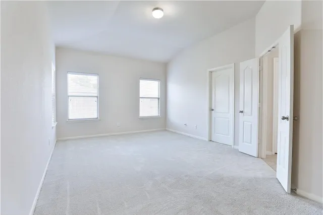 an empty room with windows and closet