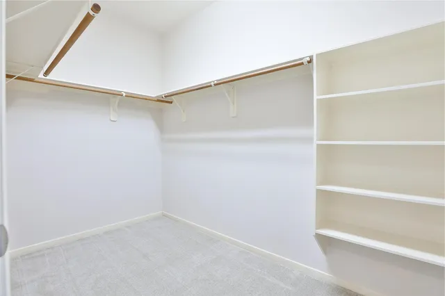 an empty room with a ceiling fan and window