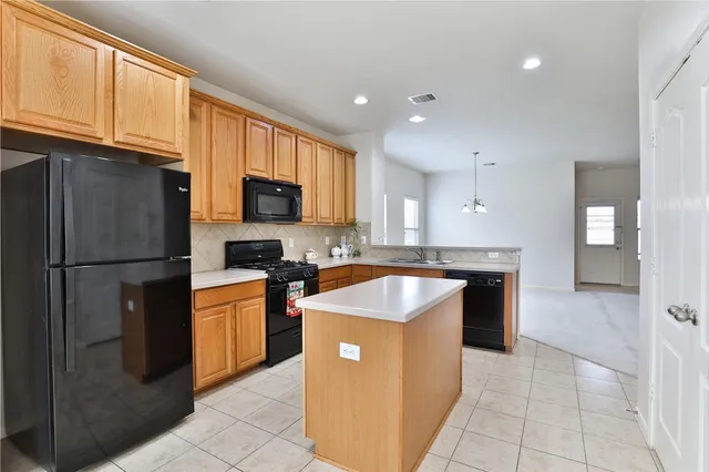 a kitchen with stainless steel appliances granite countertop a refrigerator a sink a stove with wooden cabinets