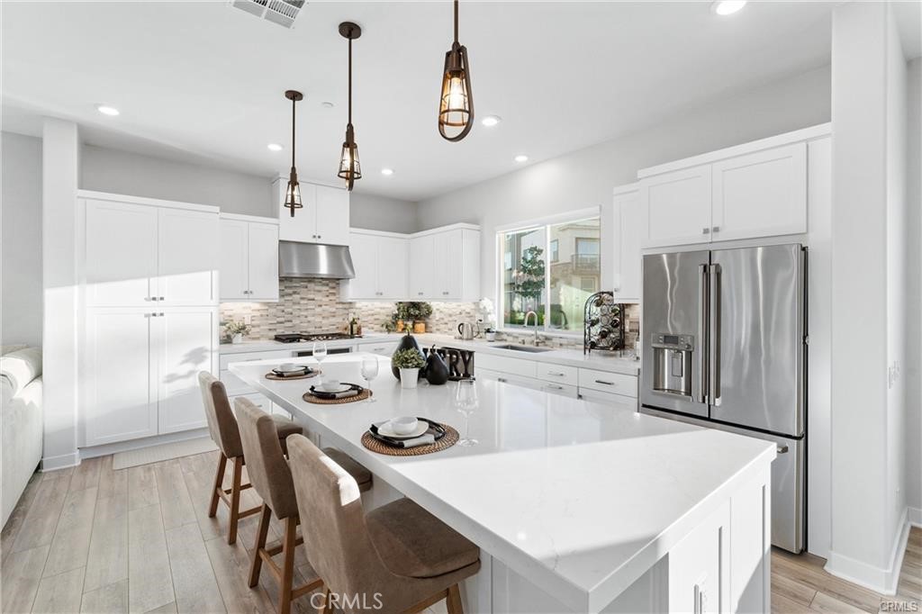 117 Denali Lake Forest, CA 92630 - Photo 3 of 40 a kitchen with stainless steel appliances a table chairs and a refrigerator
