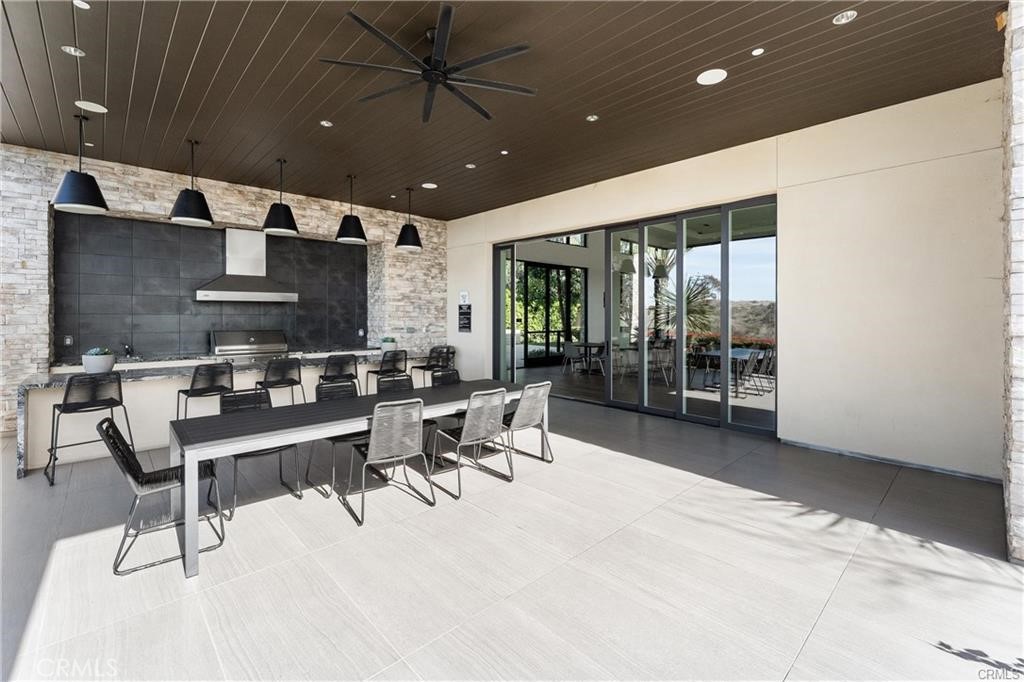 117 Denali Lake Forest, CA 92630 - Photo 38 of 40 a room with stainless steel appliances kitchen island granite countertop a table chairs sink and glass door