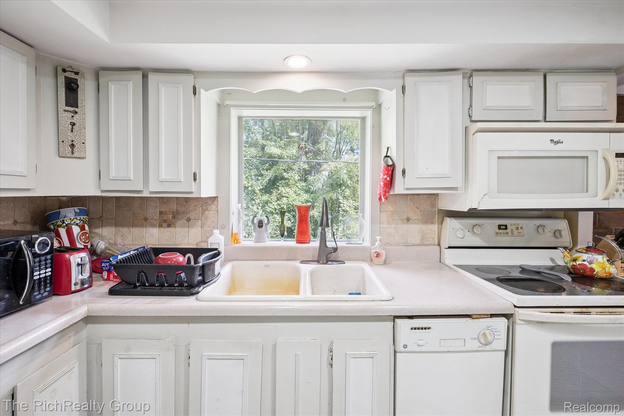 39635 Lotzford Road Canton, MI 48187 - Photo 24 of 39 Kitchen featuring white appliances, light countertops, white cabinets, and tasteful backsplash