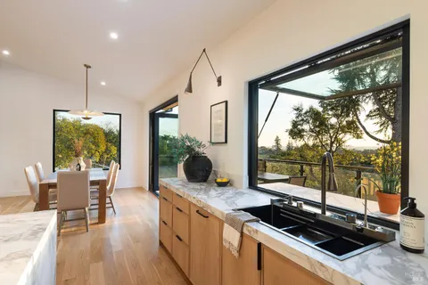 a kitchen with a stove a refrigerator a dining table and chairs with wooden floor