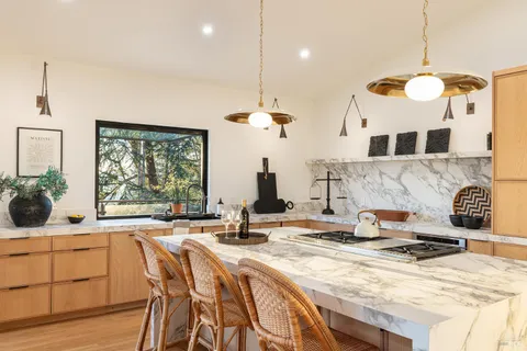 a kitchen with a stove a sink a counter space and a dining table