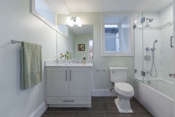9 Bartlett Crescent, Unit 1 Brookline, MA 02446 - Photo 15 of 19 a bathroom with a sink a toilet and shower