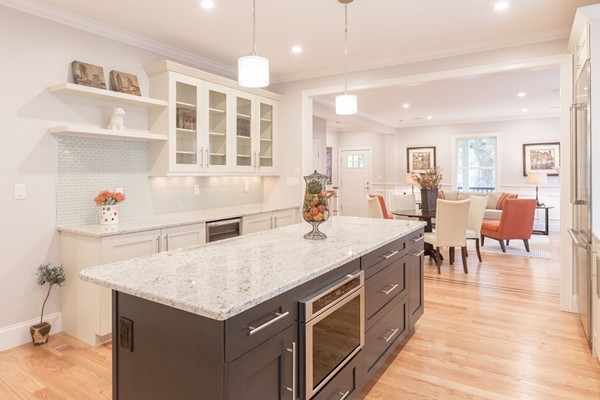 9 Bartlett Crescent, Unit 1 Brookline, MA 02446 - Photo 2 of 19 a hall with kitchen island a stove a table and chairs