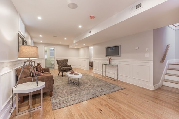 9 Bartlett Crescent, Unit 1 Brookline, MA 02446 - Photo 4 of 19 a living room with furniture a wooden floor and a sink