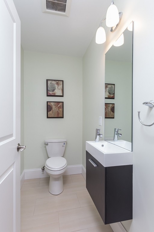 9 Bartlett Crescent, Unit 1 Brookline, MA 02446 - Photo 9 of 19 a bathroom with a toilet sink and mirror