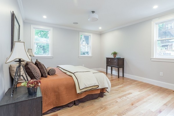 9 Bartlett Crescent, Unit 1 Brookline, MA 02446 - Photo 10 of 19 a bedroom with a bed and wooden floor