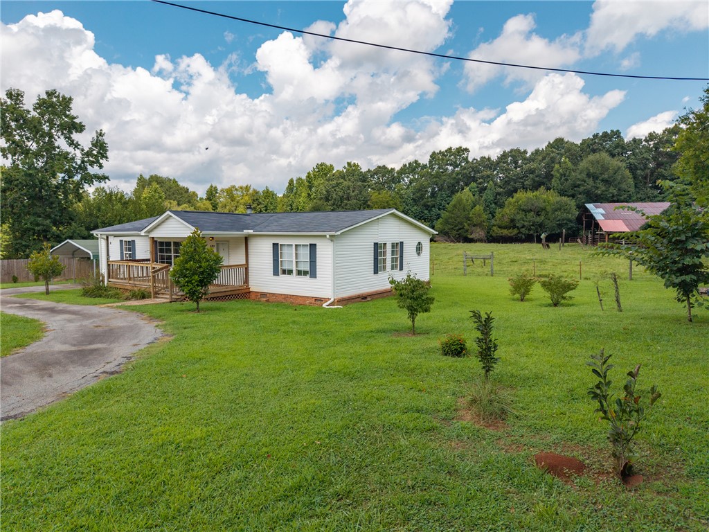 503 Mulliken Road Central, SC 29630 - Photo 46 of 50 A well-maintained white siding home offers a welcoming front porch and an expansive, verdant yard with mature trees.