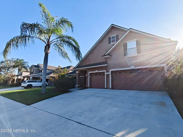 a view of a house with a yard and potted plants