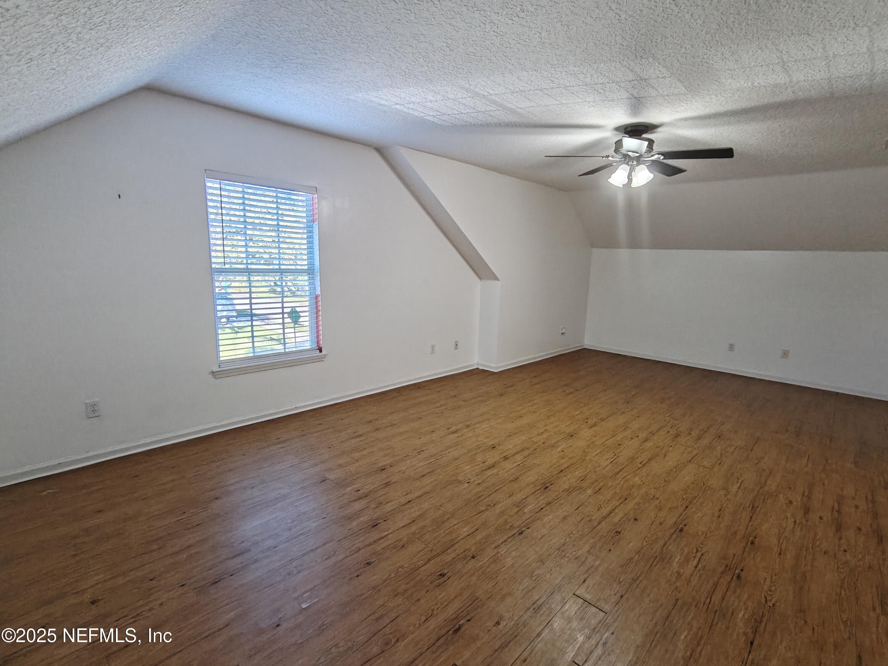 1505 Majestic View Lane Fleming Island, FL 32003 - Photo 36 of 49 an empty room with wooden floor chandelier fan and windows