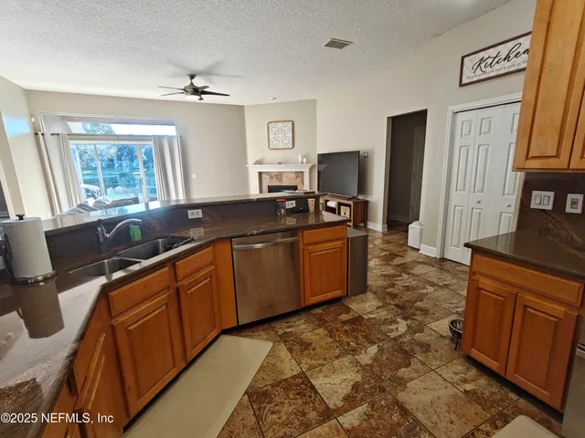 an empty room with wooden floor chandelier fan and windows