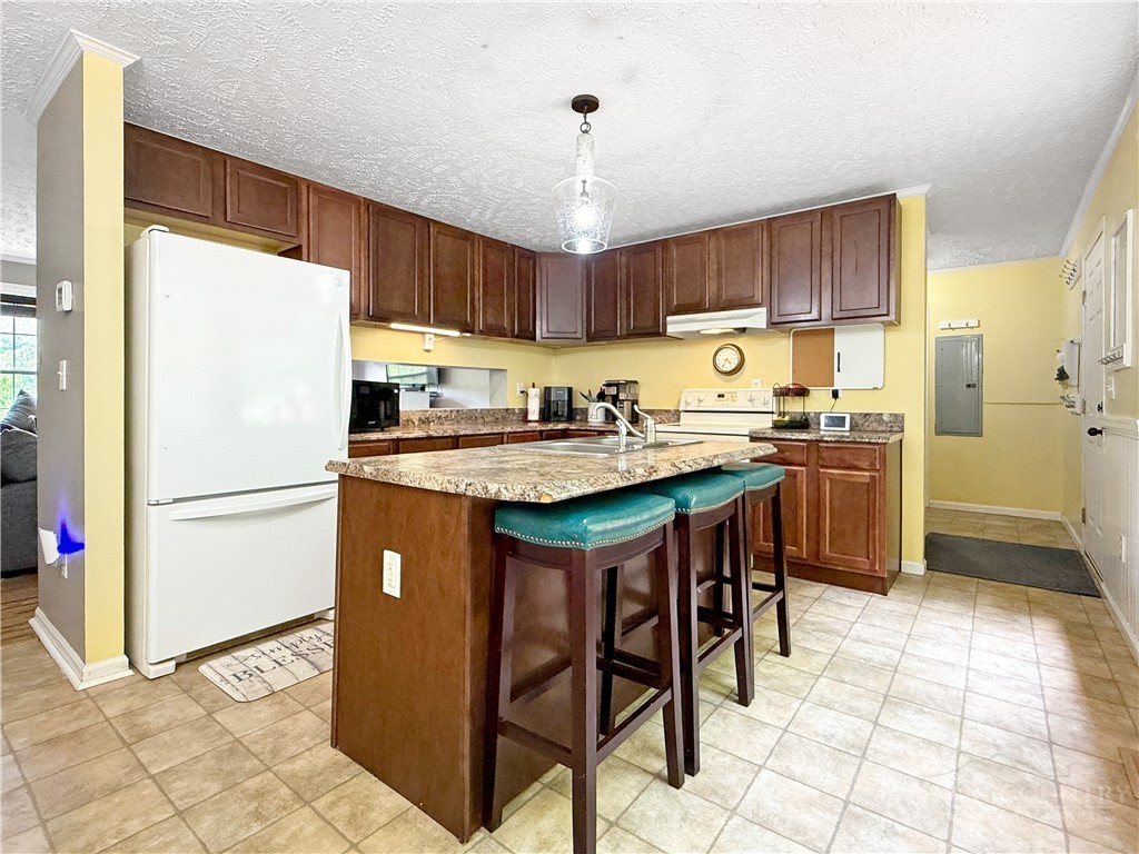 1173 Hopewell Church Road Boone, NC 28607 - Photo 6 of 39 a kitchen with stainless steel appliances granite countertop a refrigerator a sink a stove a dining table and chairs