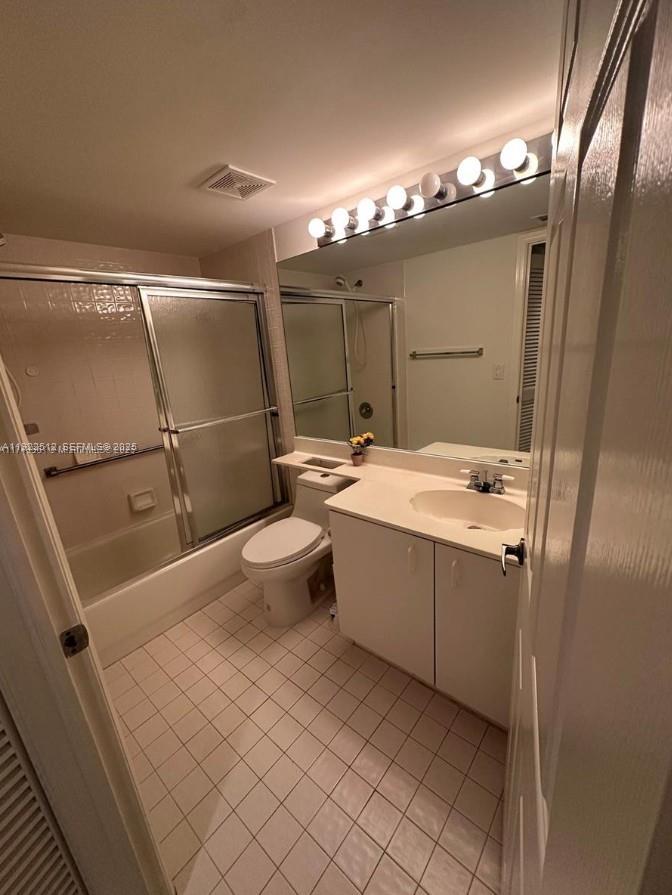 9587 Weldon Circle, Unit B203 Tamarac, FL 33321 - Photo 14 of 22 a bathroom with a sink a toilet a mirror and shower