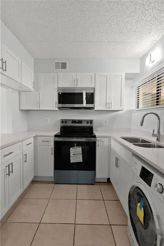 a kitchen with cabinets a sink and appliances