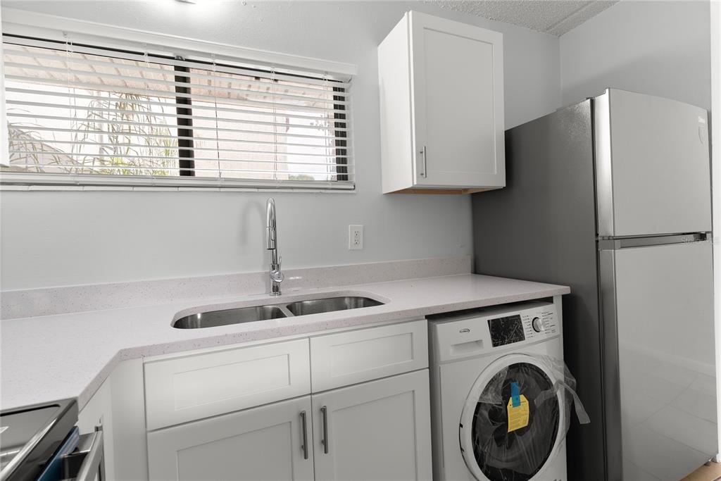 1108 Bartow Road, Unit 100 Lakeland, FL 33801 - Photo 4 of 15 a kitchen with stainless steel appliances granite countertop a sink a refrigerator and a window