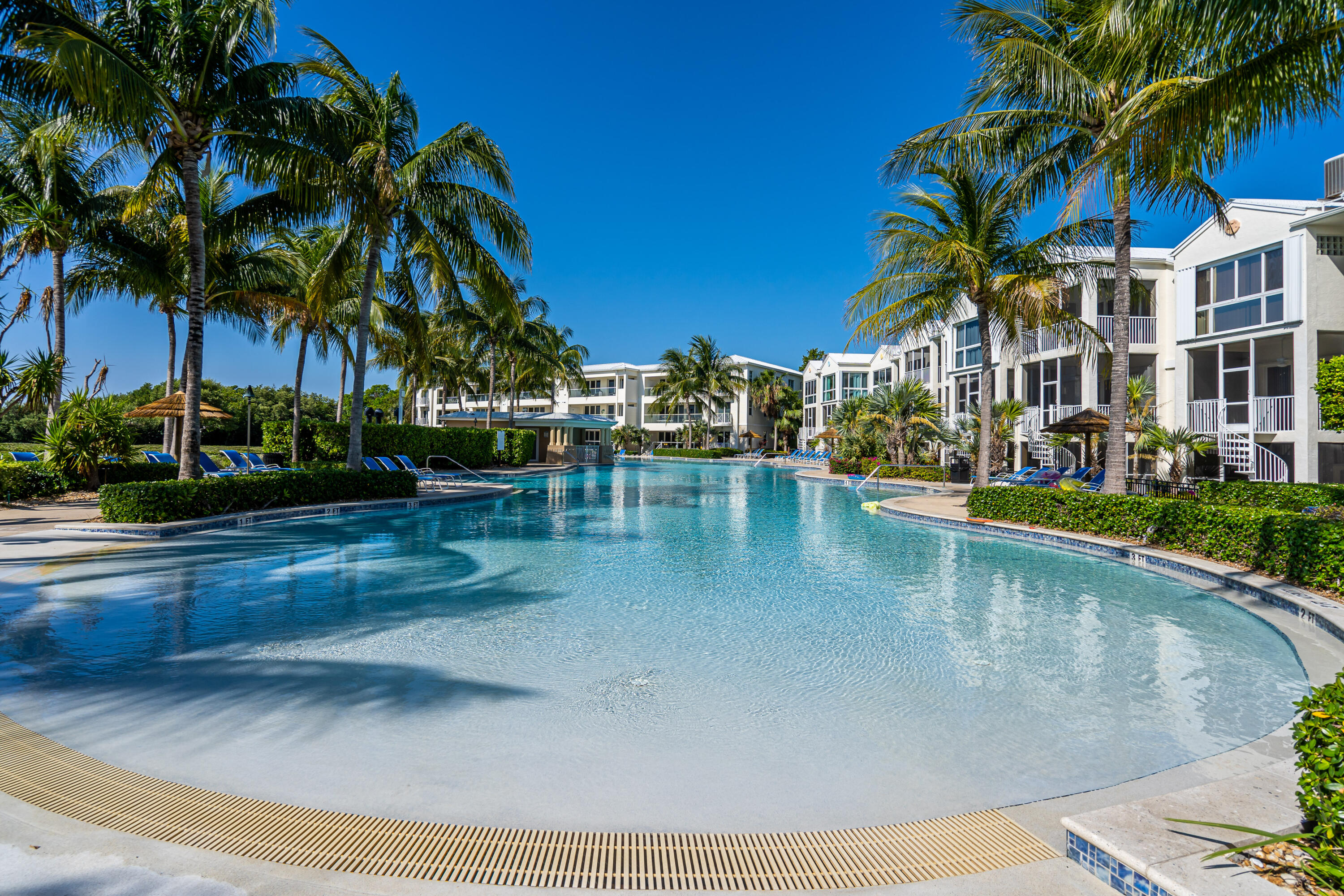 97501 Overseas Highway, Unit 607 Key Largo, FL 33037 - Photo 6 of 73 a view of a swimming pool with a garden and palm trees