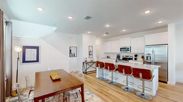 a large white kitchen with stainless steel appliances granite countertop a stove and a refrigerator