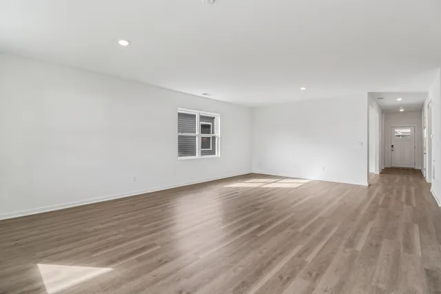 a view of an empty room with wooden floor and closet