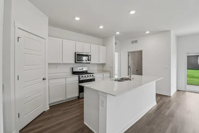 a kitchen with white cabinets and stainless steel appliances