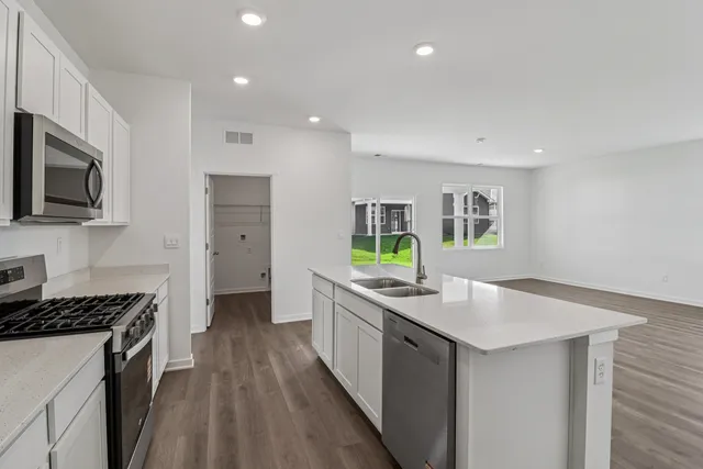 a kitchen with stainless steel appliances granite countertop a sink stove and refrigerator