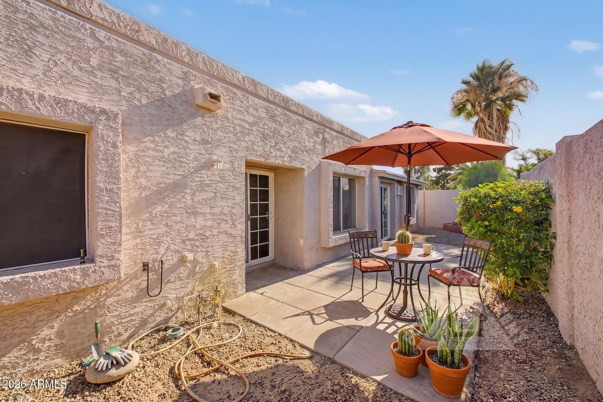 912 East Villa Rita Drive Phoenix, AZ 85022 - Photo 5 of 27 a patio with a table and chairs under an umbrella