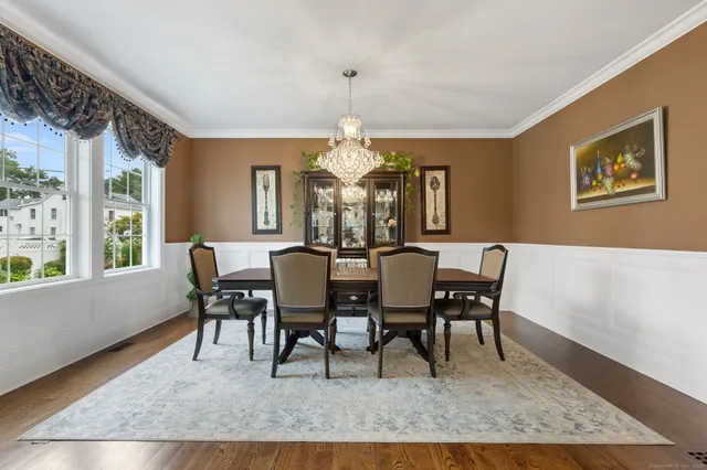 a view of a dining room with furniture a chandelier and wooden floor