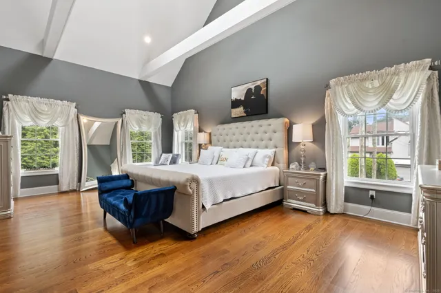 a bedroom with a bed and large wooden floor