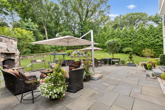 a view of a patio with chairs and a table and chairs under an umbrella