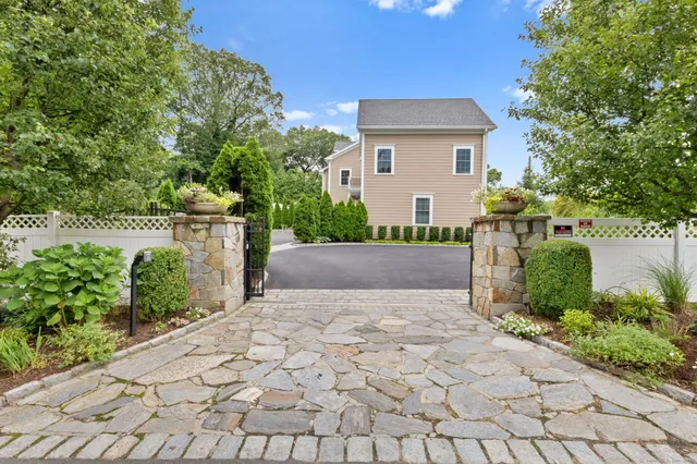 a front view of a house with a yard and a garden